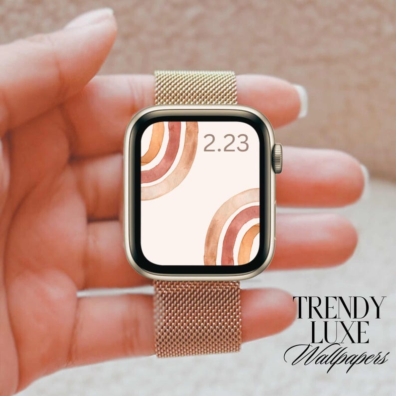 May include: A gold Apple Watch with a brown and orange abstract design watch face. The time is 2:23.