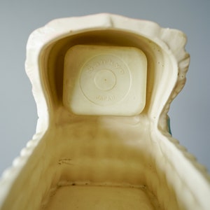 May include: A white ceramic baby crib with a removable white plastic insert that reads "Star-Kist Japan".