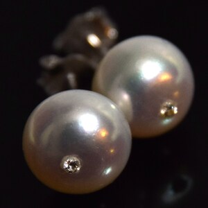Op de afbeelding: Een paar parel oorbellen met een klein diamant accent op elke parel.