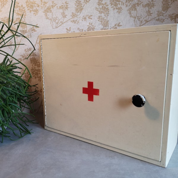 Vintage wooden first aid cabinet, white painted wood with a red cross in the middle, hanging medicine cabinet, bathroom wall cabinet.