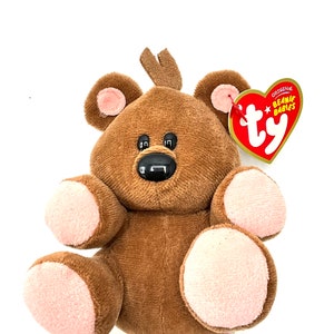 May include: Brown plush bear with pink paws and a Ty Beanie Babies tag. The tag is red with white text that reads "Original Beanie Babies Ty".