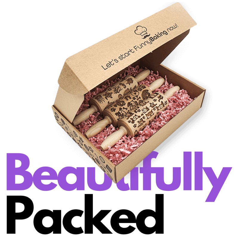 Peut inclure: Trois rouleaux &agrave; p&acirc;tisserie en bois grav&eacute;s dans une bo&icirc;te en carton marron avec du papier cr&eacute;pon rose. La bo&icirc;te porte l'inscription "Let's start FunnyBaking now!" imprim&eacute;e sur le dessus.