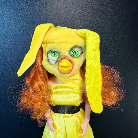 A one-of-a-kind OOAK 'cursed pregnant' Long Furby art doll that sits firmly in the unsettling-yet-fascinating intersection of weirdcore, outsider art, and handmade toy craft.