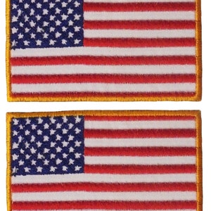May include: Two embroidered American flag patches with a gold border. The flags are red, white, and blue.