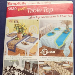 May include: A Simplicity pattern for home decorating, featuring various table top accessories. The image showcases different table runners, place mats, and a table cloth with bands. The color palette includes blue, white, black, and brown.