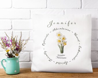 May include: White throw pillow with a floral design and the name Jennifer. The pillow has a circle with the words "Adventurous, Honest, Enthusiastic, Optimistic, Spirited, Friendly" and a drawing of a daffodil with the text "December Narcissus".