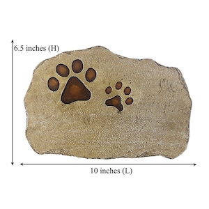 May include: A tan, textured stone-like plaque featuring two recessed paw prints in a darker brown shade. The plaque measures 6.5 inches in height and 10 inches in length, as indicated by the black arrows and text labels on the image.