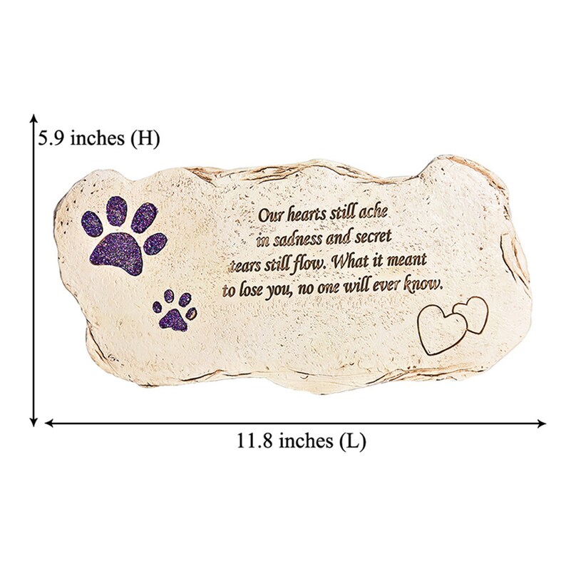 May include: A beige stone-shaped memorial plaque, 30 cm long and 15 cm high, with purple glitter paw prints and a heart design. The inscription reads: "Our hearts still ache in sadness and secret tears still flow. What it meant to lose you, no one will ever know."