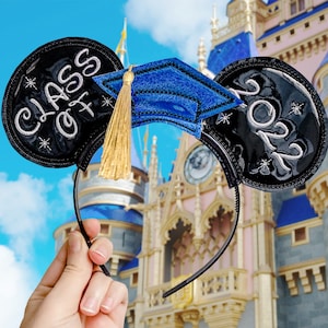 May include: Black and white mouse ears with a blue graduation cap. The ears say "Class of 2023" and "Class of 2023".