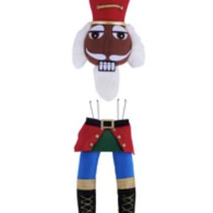 May include: A plush Christmas nutcracker doll with a red hat and uniform. The doll's head features a brown face, white mustache, and a white beard. The lower half has blue pants, a red jacket, and black boots.