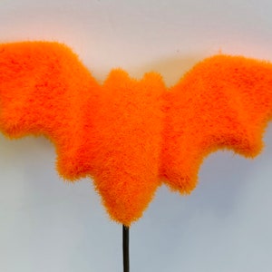 May include: Orange fuzzy bat Halloween decoration with a black wire stem.