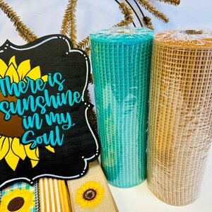 May include: A wreath making kit with a black sign that says "There is sunshine in my soul", a teal and a brown mesh ribbon, and three sunflower patterned ribbons.