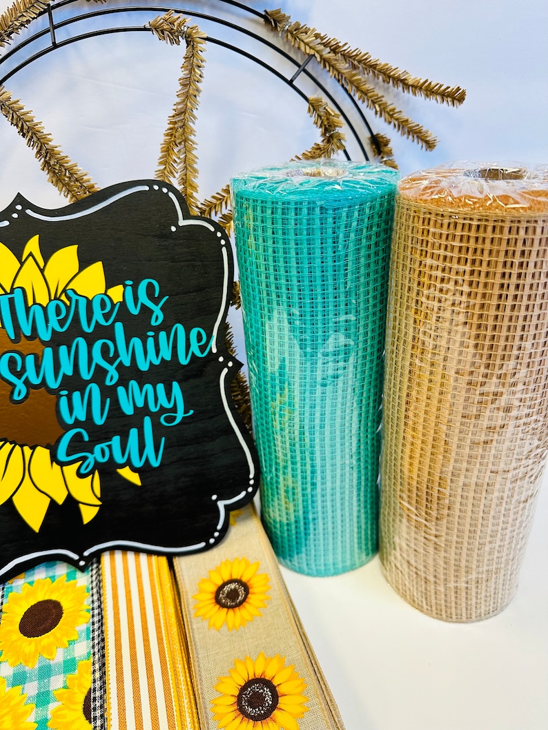 May include: A wreath making kit with a black sign that says "There is sunshine in my soul", a teal and a brown mesh ribbon, and three sunflower patterned ribbons.