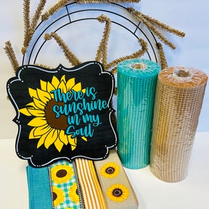 May include: A wreath making kit with a black wooden sign that says "There is sunshine in my soul", a teal and brown mesh ribbon, and three different ribbons with sunflower patterns.