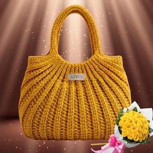Può includere: Borsa a mano all'uncinetto giallo senape con un design a coste e due manici. La borsa ha una piccola etichetta rettangolare con la scritta "AZVOS". Un bouquet di rose gialle è accanto alla borsa.