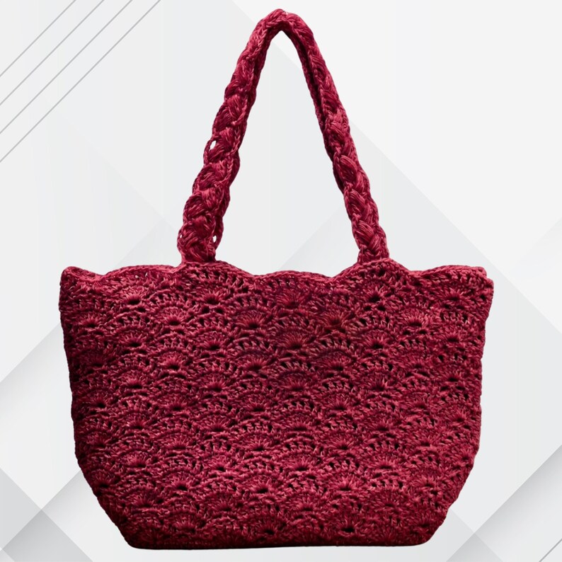 May include: A burgundy crochet tote bag with a scalloped top edge and braided handles. The bag features a detailed openwork pattern throughout the body. The handles are thick and sturdy, designed for comfortable carrying. The bag is a stylish accessory.