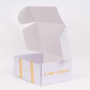 May include: White cardboard box with a gold logo that says "Daisy Fields". The box is open and the lid is folded back.