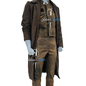 Puede incluir: Un conjunto marrón de tres piezas sobre un maniquí. El conjunto incluye un abrigo largo, un chaleco y pantalones. El abrigo es de un tono marrón más oscuro, mientras que el chaleco y los pantalones son de un tono más claro. El conjunto tiene una apariencia robusta y desgastada.