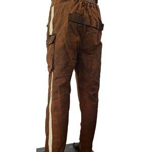 May include: Brown cargo pants with a white stripe down the side of each leg. The pants have a drawstring waist and a belt.