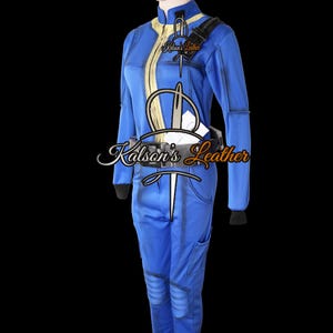 May include: Blue jumpsuit with yellow accents, a black shoulder strap, and a matching belt. The jumpsuit features a zipper down the front and pockets on the legs. The text "Kalson's Leather" is visible on the chest.