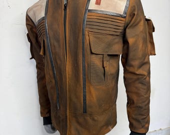 May include: Brown jacket with a high collar, black accents, and multiple pockets. The jacket features a red stripe on the shoulder and a black cuff. The jacket is displayed on a mannequin.