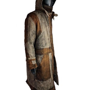 May include: A long, brown and grey hooded coat with a distressed look. The coat has a zip closure and multiple pockets.