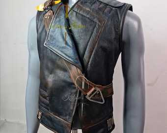 May include: A distressed black leather vest with brown accents and a buckle closure. The vest features a unique asymmetrical design with a notched collar and quilted shoulder details. The vest is displayed on a mannequin.