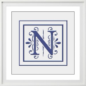 Puede incluir: Un monograma azul y blanco con la letra N en un marco decorativo. La letra N está en una fuente en negrita y estilizada con adornos.