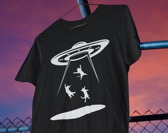 May include: Black t-shirt with a white graphic of a UFO abducting three cats.