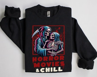 Może przedstawiać: Czarna bluza z nadrukiem dwóch szkieletów, które się obejmują. Szkielety noszą szaty z kapturem. Pod nadrukiem znajduje się napis "HORROR MOVIES & CHILL".