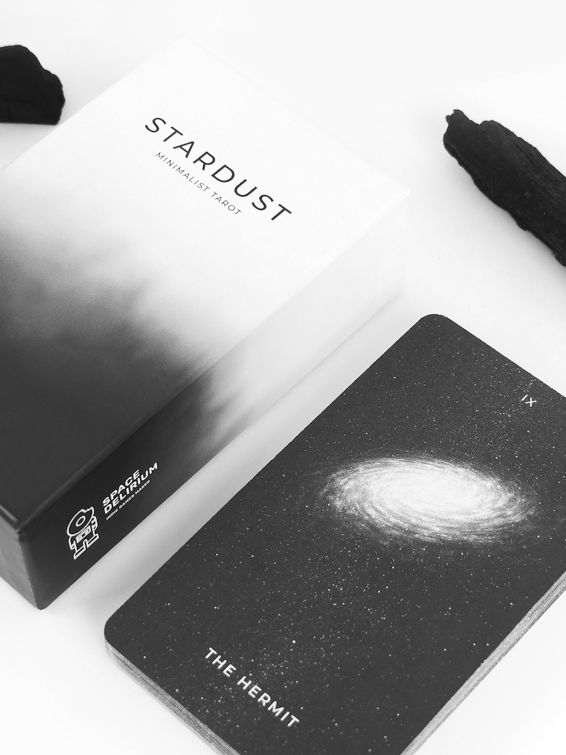 May include: A black and white tarot card with a galaxy image and the text "The Hermit" and "IX". The card is from the Stardust Minimalist Tarot deck.