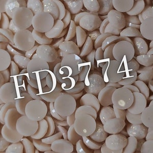 Peut inclure: Gros plan sur une grande quantité de petits strass ronds, plats, de couleur blanc cassé et irisés. Les strass sont dispersés de manière aléatoire et le texte "FD3774" est visible au centre de l'image.