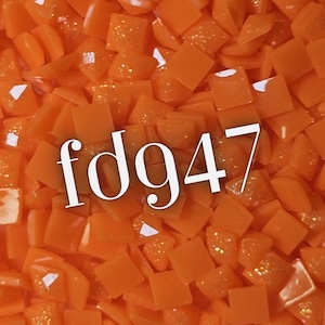 May include: A close-up of a pile of small, square, orange glass tiles. The tiles have a glossy finish and some have glitter embedded. The text "fd947" is overlaid on the tiles in a white, sans-serif font.