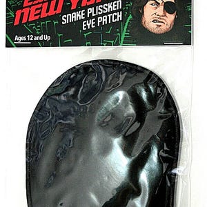 May include: A black Snake Plissken eye patch from the movie "Escape From New York." The packaging includes the movie title and character image. The eye patch is in a clear plastic bag. The text "Ages 12 and Up" is also visible.