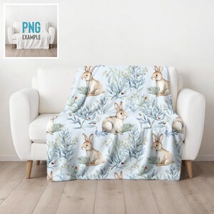 May include: A soft blue throw blanket with a repeating pattern of watercolor bunnies and leafy branches. The bunnies are brown and white and the branches are blue and green.
