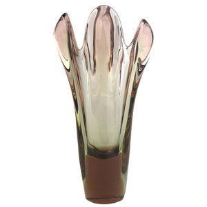 Könnte beinhalten: Eine klare Glasvase mit einer einzigartigen, organischen Form. Die Vase hat einen hellgrünen und braunen Farbübergang.