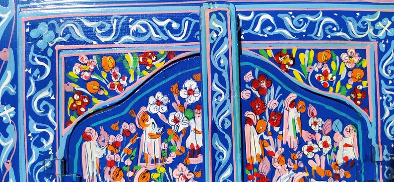 May include: A blue wooden panel featuring intricate floral and geometric designs painted in vibrant colours, including pink, yellow, orange, and white.
