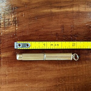 This rare 9K solid gold retractable toothpick—a unique and sophisticated blend of functionality and refinement. making a perfect gifts for luxury EDC (everyday carry) enthusiasts, or those who appreciate unconventional fine jewelry. This handcrafted piece merges discreet utility with old-world craftsmanship.  An unforgettable conversation starter for fans of unique gadgets, historical pocket accessories.