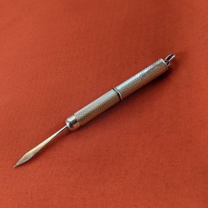 This rare 9K solid gold retractable toothpick—a unique and sophisticated blend of functionality and refinement. making a perfect gifts for luxury EDC (everyday carry) enthusiasts, or those who appreciate unconventional fine jewelry. This handcrafted piece merges discreet utility with old-world craftsmanship.  An unforgettable conversation starter for fans of unique gadgets, historical pocket accessories.