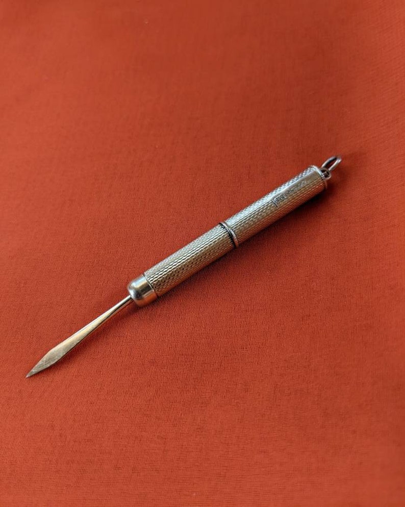 This rare 9K solid gold retractable toothpick—a unique and sophisticated blend of functionality and refinement. making a perfect gifts for luxury EDC (everyday carry) enthusiasts, or those who appreciate unconventional fine jewelry. This handcrafted piece merges discreet utility with old-world craftsmanship.  An unforgettable conversation starter for fans of unique gadgets, historical pocket accessories.