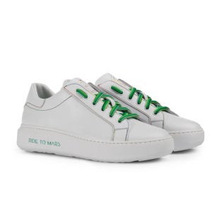 Puede incluir: Zapatillas bajas de cuero blanco con cordones verdes y un dise&ntilde;o de arco&iacute;ris en el lateral. Las zapatillas tienen una suela de goma blanca con el texto "RIDE TO MARS" impreso en el lateral.