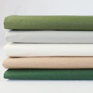 May include: A stack of five tissue paper sheets in different colors: green, gray, white, beige, and dark green.