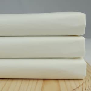 May include: Three white fabric squares stacked on top of each other on a wooden surface.