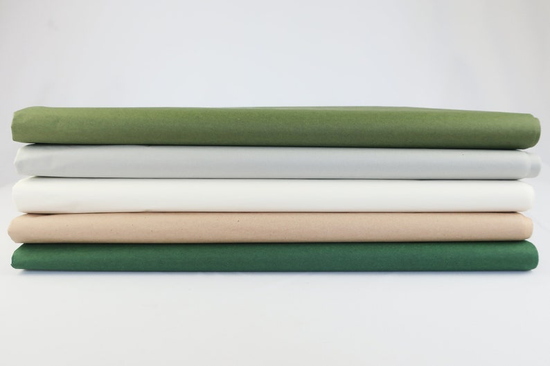 May include: A stack of five tissue paper sheets in different colors: green, gray, white, beige, and dark green.