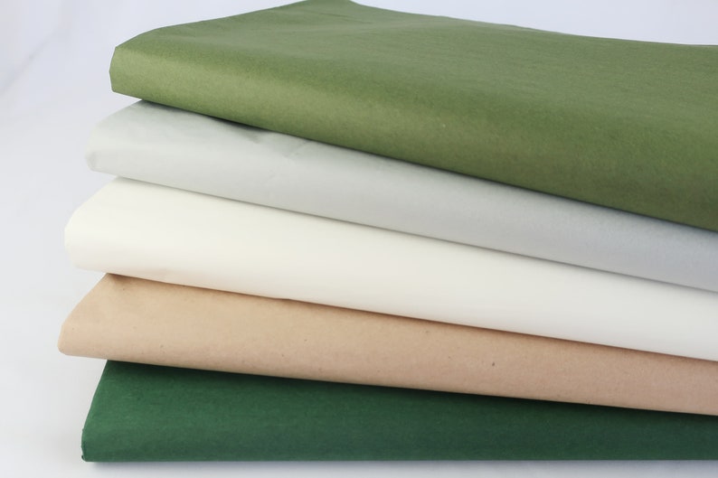 May include: Five sheets of tissue paper in different colors: green, gray, white, beige, and dark green.