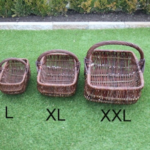 May include: Three brown wicker baskets with handles, labeled L, XL, and XXL. The baskets are on a green artificial grass surface.