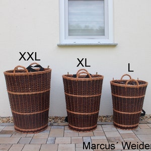 Könnte beinhalten: Drei Weidenkörbe in verschiedenen Größen, beschriftet mit XXL, XL und L. Die Körbe sind braun und haben schwarze Griffe.