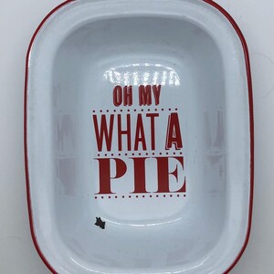 Könnte beinhalten: Weiße Tortenform mit rotem Rand und dem Text "Oh My What A Pie" in Rot.