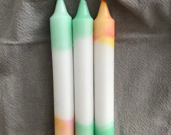 Könnte beinhalten: Drei Ombre-Kerzen, eine mit einem grünen und weißen Ombre, eine mit einem rosa und weißen Ombre und eine mit einem gelben und weißen Ombre.
