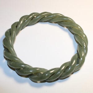 May include: A green jade bangle bracelet with a twisted rope design.